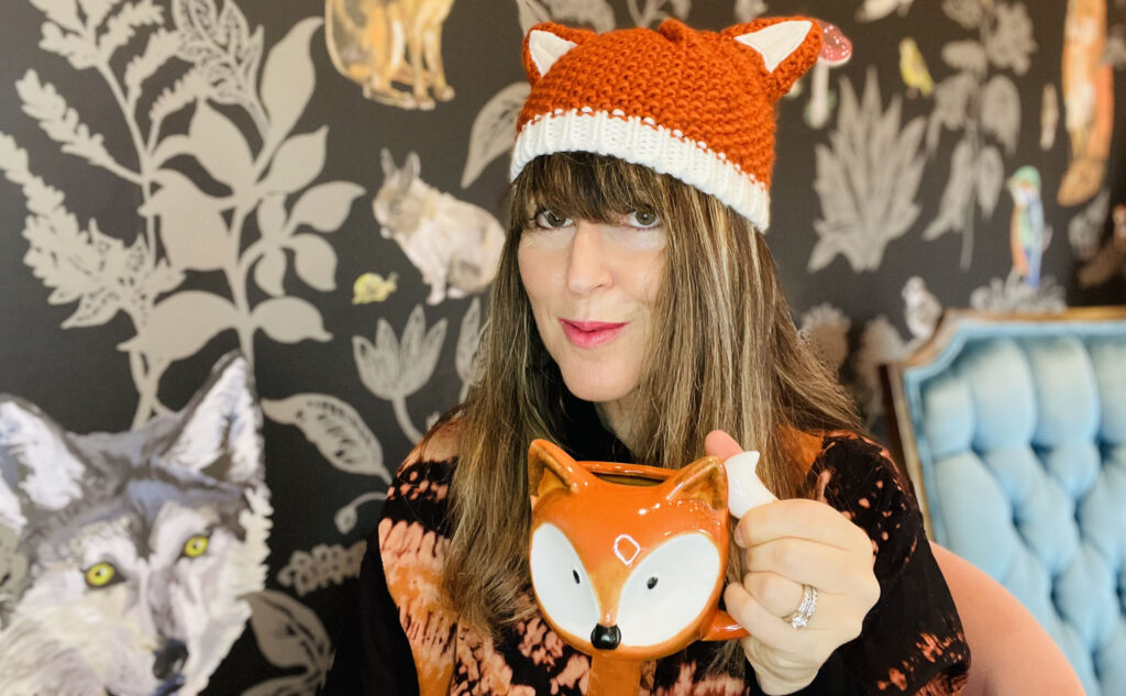 Jess enjoys her ginger turmeric tea in a fox mug, and while wearing a fox hat